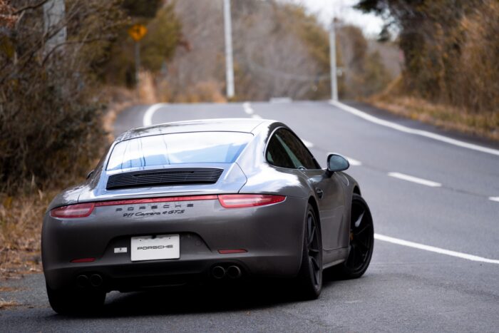 Porsche 911 running on a wide-area farm road